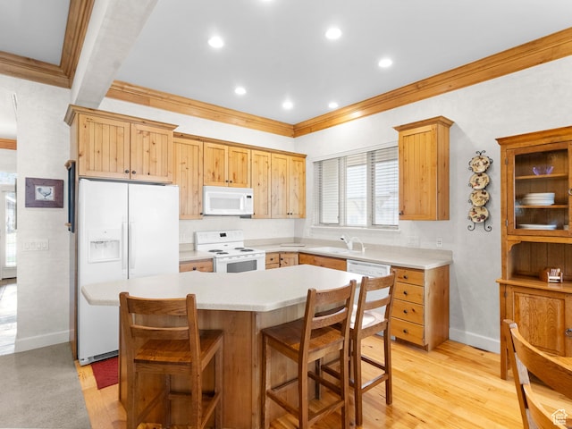 kitchen featuring baseboards, ornamental molding, white appliances, light countertops, and a sink