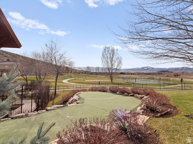 exterior space featuring a mountain view, fence, and a lawn