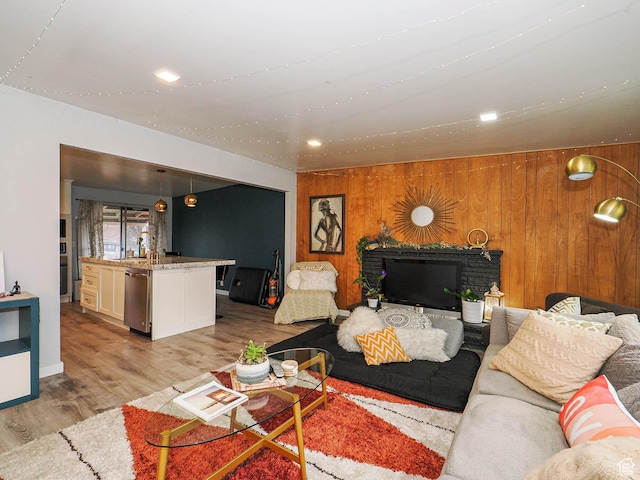living area featuring light wood-type flooring, wood walls, and recessed lighting