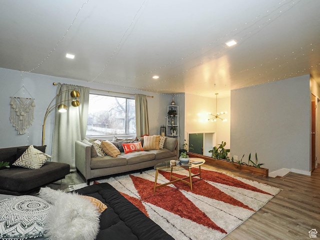 living area featuring recessed lighting, a notable chandelier, baseboards, and wood finished floors
