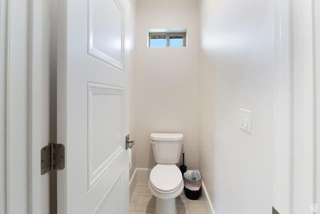 bathroom with toilet and baseboards