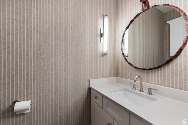 bathroom with wallpapered walls and vanity
