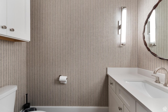 half bathroom with vanity and toilet
