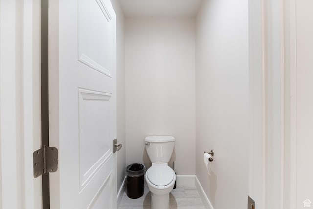 bathroom featuring baseboards and toilet