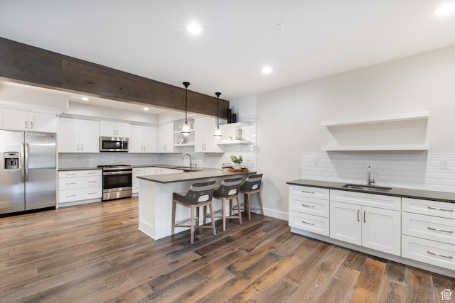 kitchen featuring open shelves, stainless steel appliances, a sink, and dark countertops