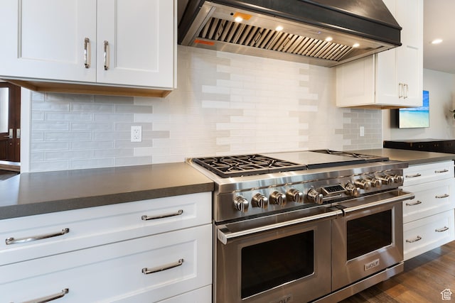 kitchen featuring dark countertops, tasteful backsplash, custom range hood, and double oven range