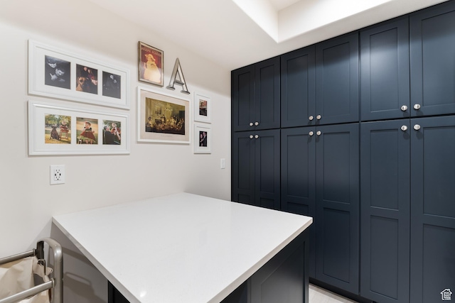 kitchen featuring a peninsula, light countertops, and blue cabinets