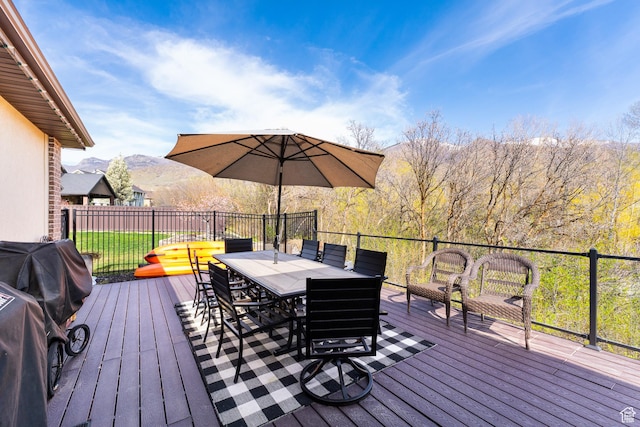 wooden terrace featuring outdoor dining area and a mountain view