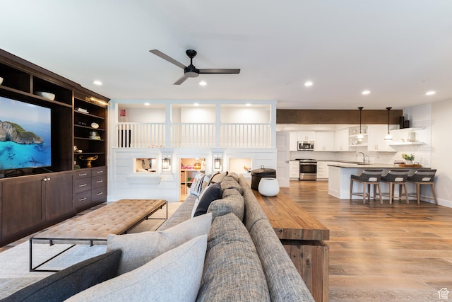 living area featuring recessed lighting, a ceiling fan, and light wood-type flooring