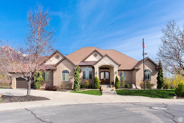 view of front of house with concrete driveway, french doors, a garage, brick siding, and roof with shingles