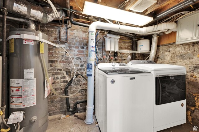 laundry room with water heater, independent washer and dryer, and laundry area