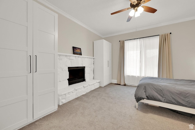 bedroom featuring crown molding, carpet, a ceiling fan, a stone fireplace, and baseboards