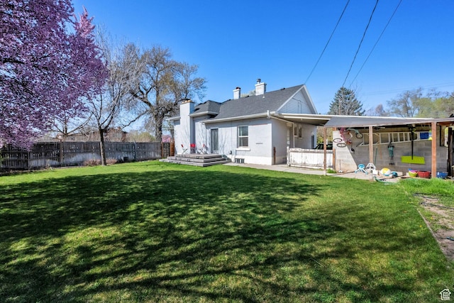 rear view of property with a patio, a chimney, fence, and a lawn