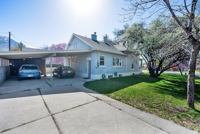 view of home's exterior with driveway, an attached carport, a lawn, and a chimney
