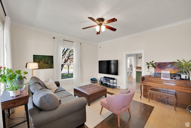 living area featuring wood finished floors, baseboards, crown molding, and ceiling fan