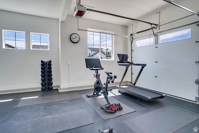 workout area featuring a garage and baseboards