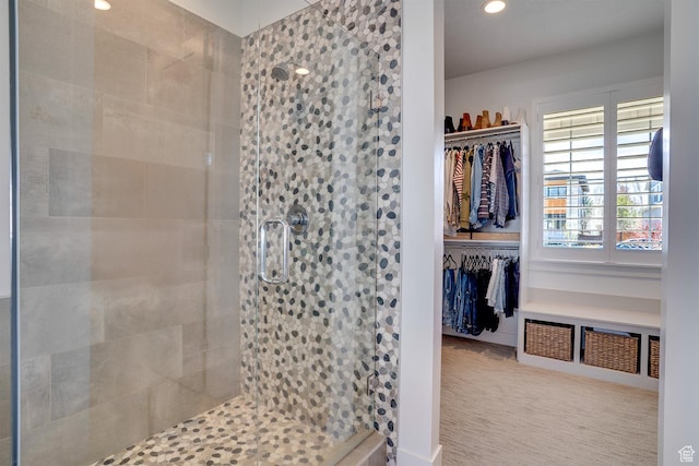 bathroom with recessed lighting, a walk in closet, and a stall shower