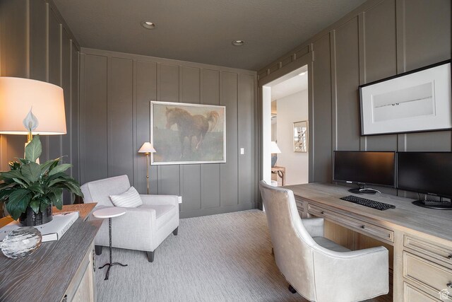 office space featuring recessed lighting, a decorative wall, and carpet