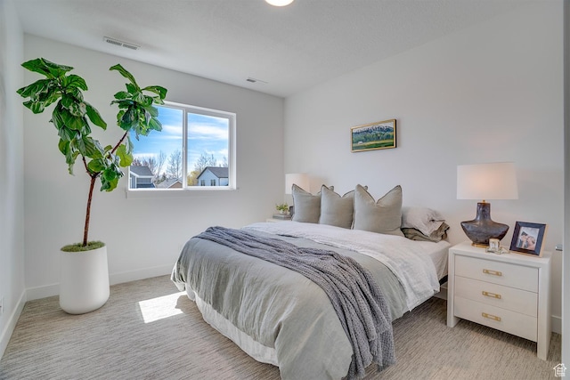 carpeted bedroom with visible vents and baseboards