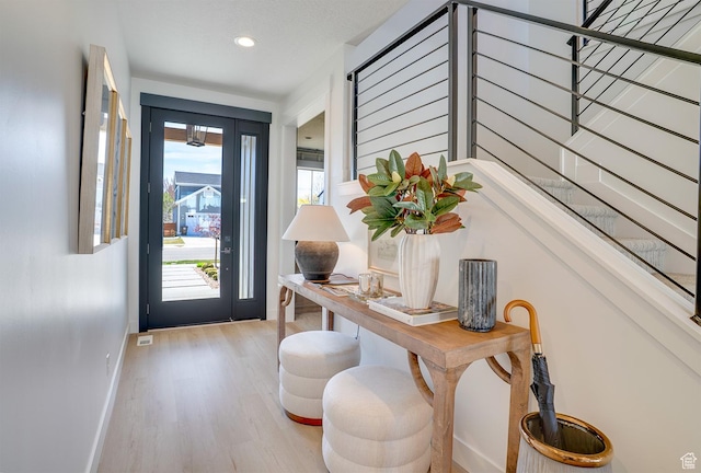 entryway with light wood-type flooring, baseboards, and recessed lighting