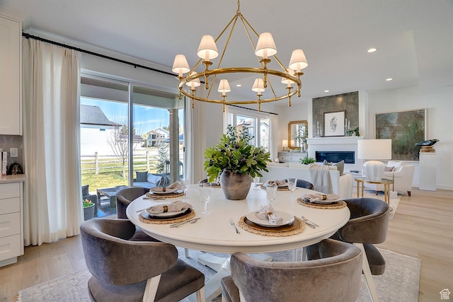 dining space featuring light wood-style flooring, a wealth of natural light, and an inviting chandelier