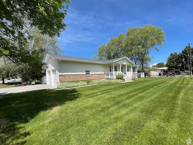 129 N 3rd E, Franklin, ID 83237 - view of front of property featuring a porch, brick siding, a front yard, driveway, and a garage