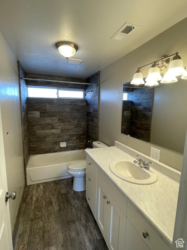 129 N 3rd E, Franklin, ID 83237 - full bath with washtub / shower combination, vanity, toilet, visible vents, and wood finished floors