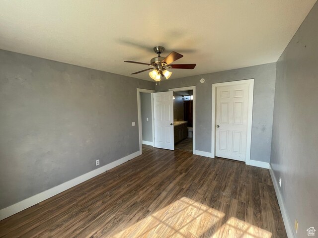 129 N 3rd E, Franklin, ID 83237 - unfurnished bedroom featuring dark wood-type flooring, ensuite bath, baseboards, and a ceiling fan