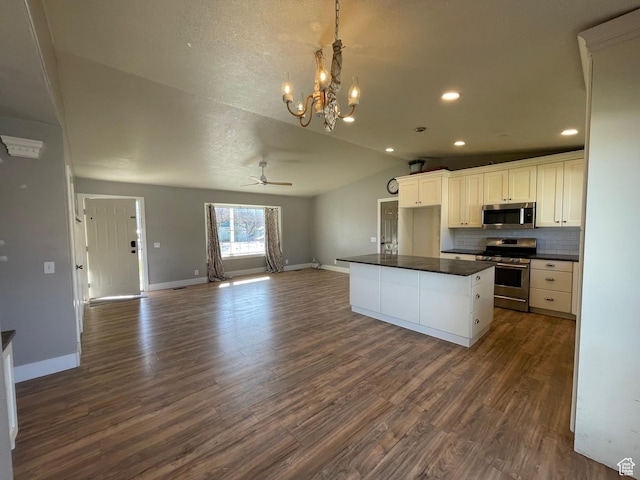 129 N 3rd E, Franklin, ID 83237 - kitchen featuring vaulted ceiling, appliances with stainless steel finishes, dark countertops, open floor plan, and backsplash