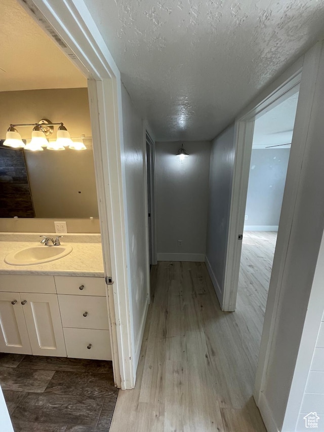 129 N 3rd E, Franklin, ID 83237 - hall with a sink, baseboards, wood finished floors, and a textured ceiling