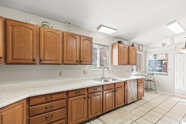 kitchen featuring a sink, brown cabinetry, light countertops, and dishwasher