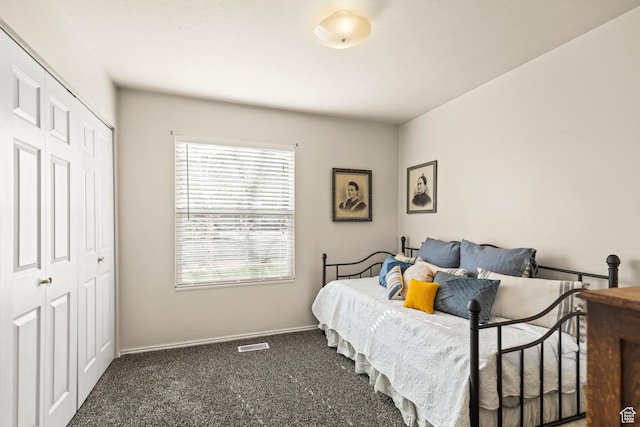 carpeted bedroom with a closet, baseboards, and visible vents