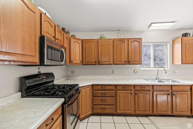 kitchen with stainless steel appliances, brown cabinets, and a sink