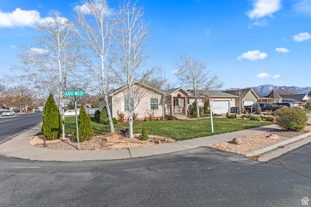 view of front of property featuring a mountain view, a residential view, and a front lawn
