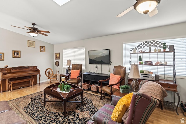 living room featuring a ceiling fan, plenty of natural light, wood finished floors, and lofted ceiling