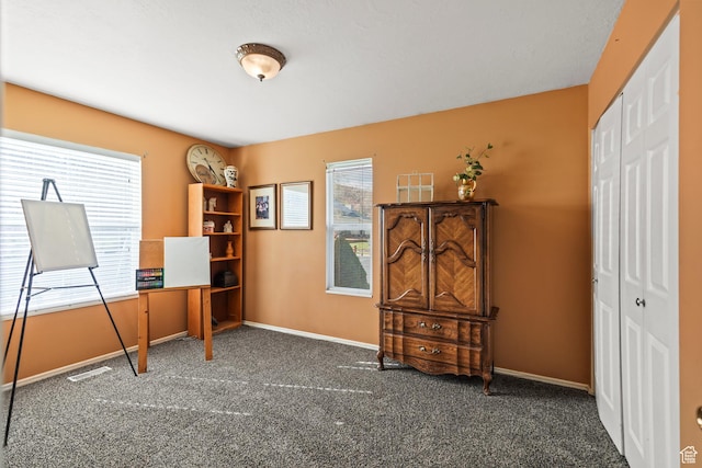 carpeted home office featuring visible vents and baseboards