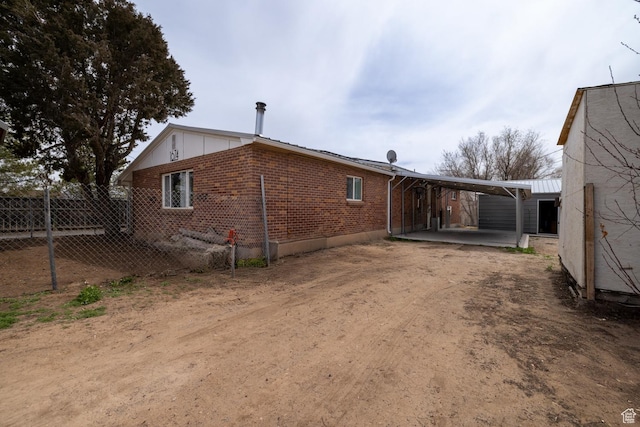1674 E 1700 S, Naples, UT 84078 - view of property exterior featuring a detached carport, dirt driveway, fence, and brick siding