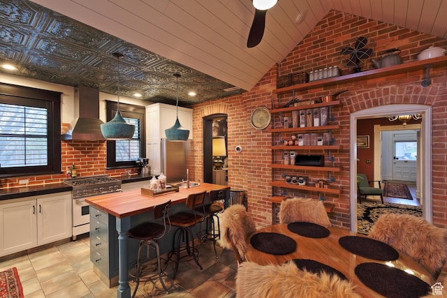 135 W 600 N, Salt Lake City, UT 84103 - kitchen with vaulted ceiling, stainless steel stove, brick wall, butcher block countertops, and extractor fan
