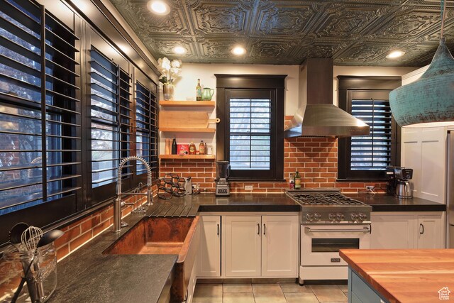 135 W 600 N, Salt Lake City, UT 84103 - kitchen featuring high end stainless steel range, ventilation hood, white cabinets, a sink, and butcher block countertops