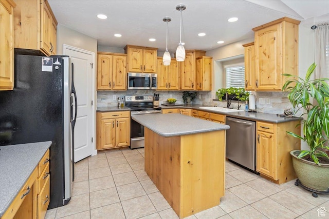 kitchen with appliances with stainless steel finishes, a sink, backsplash, and a kitchen island