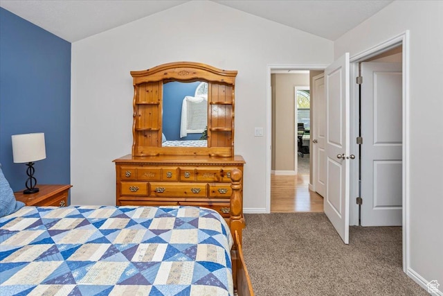 carpeted bedroom with baseboards and lofted ceiling