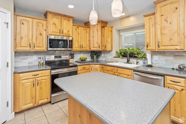 kitchen with light tile patterned floors, a center island, a sink, stainless steel appliances, and decorative backsplash