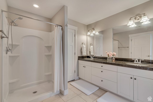bathroom with tile patterned floors, double vanity, a sink, and a stall shower