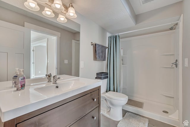full bath featuring toilet, vanity, and a stall shower
