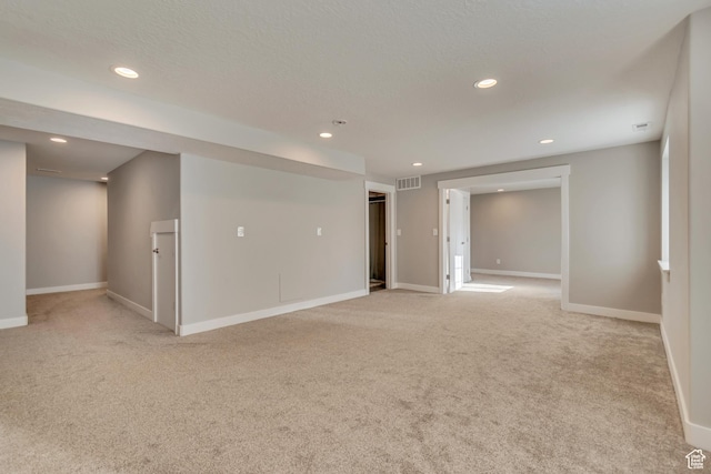 unfurnished room with visible vents, baseboards, recessed lighting, and light carpet