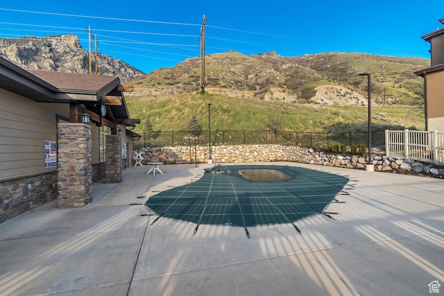 view of pool with fence, a patio, a mountain view, and a fenced in pool