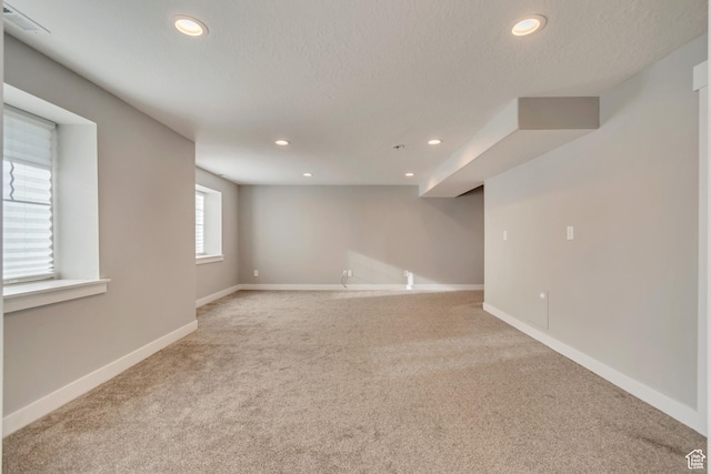 below grade area featuring carpet floors, baseboards, recessed lighting, and visible vents