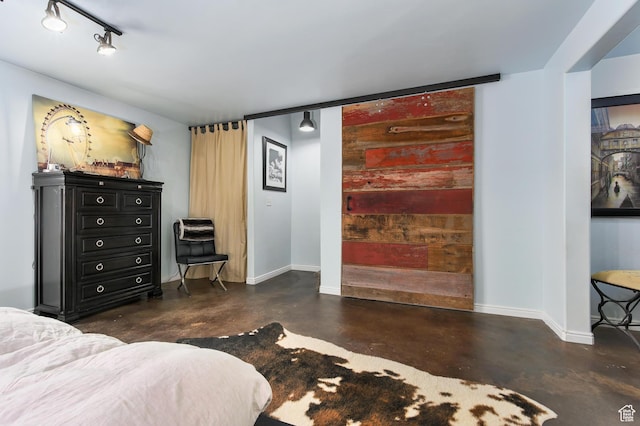 bedroom featuring concrete flooring and baseboards