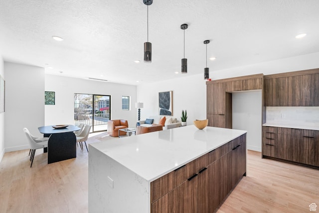 4372 S 900 E Unit 102, Millcreek, UT 84124 - kitchen with modern cabinets, light wood finished floors, light countertops, a center island, and recessed lighting
