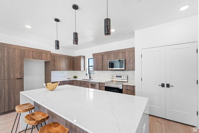 4372 S 900 E Unit 102, Millcreek, UT 84124 - kitchen with stainless steel appliances, modern cabinets, a sink, a kitchen breakfast bar, and tasteful backsplash